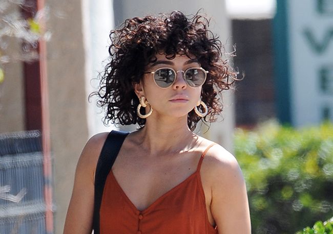 Sarah Hyland con pelo rizado y gafas de sol redondas