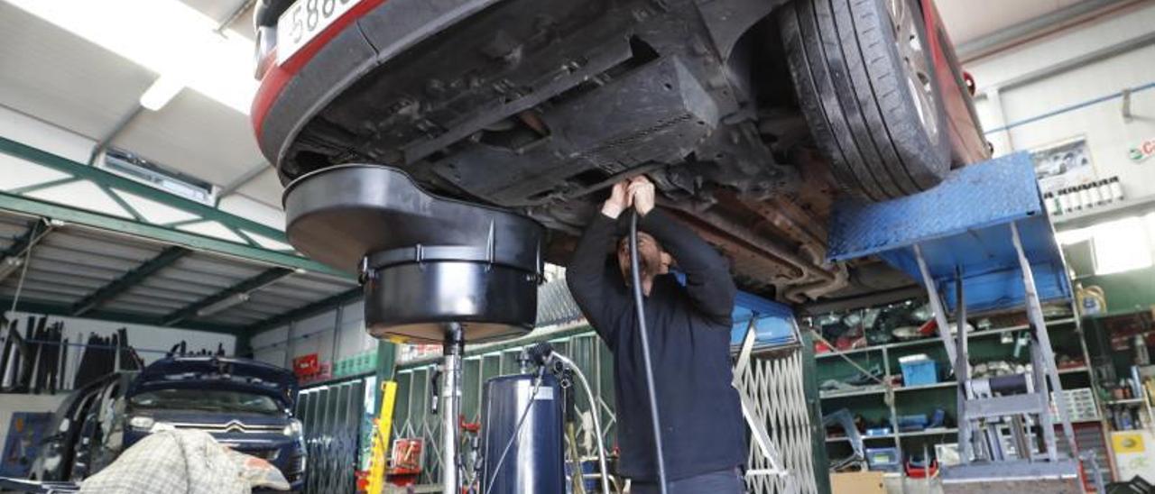 Mecánico repara un coche en un taller de Chapela. |   // RICARDO GROBAS