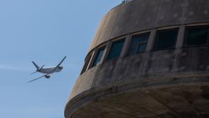 Un avión de Vueling pasa cerca de la torre de control del aeropuerto de Barcelona.