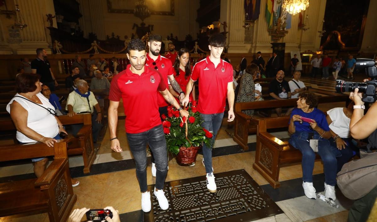 Los capitanes de los tres equipos del Casademont entran a la Basílica de Pilar portando una cesta con flores.