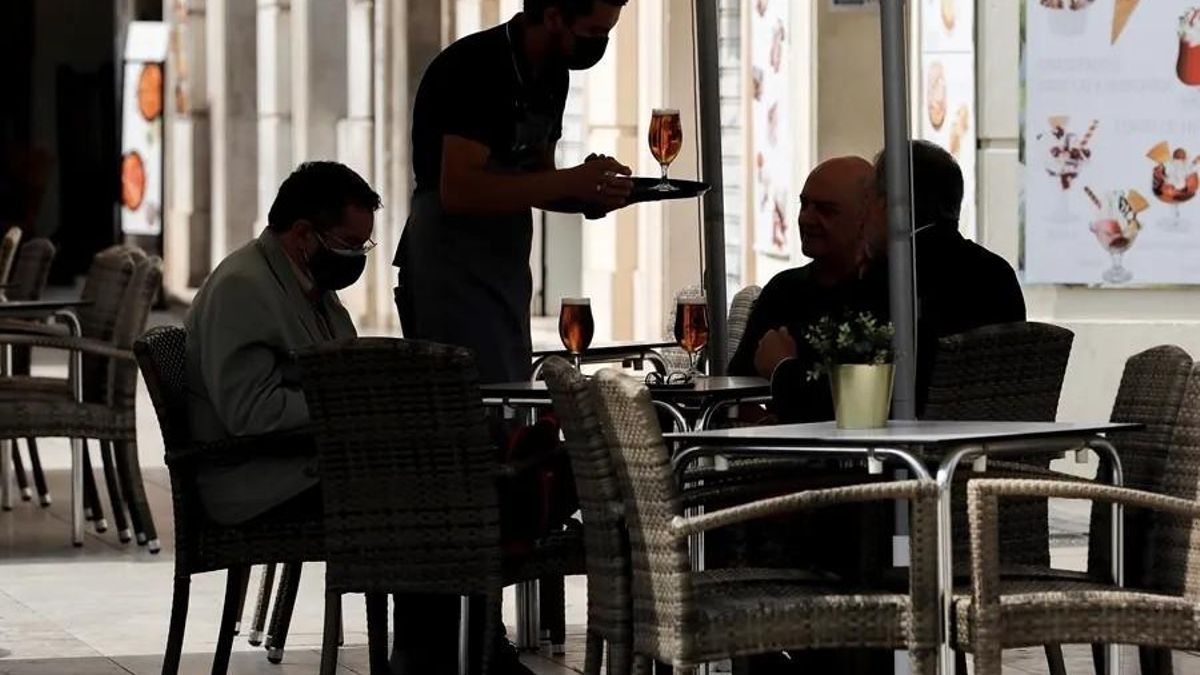 Un camarero sirviendo en la terraza de un restaurante