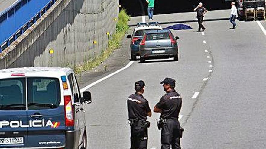 La policía en el lugar del suceso. Al fondo, uno de los fallecidos.