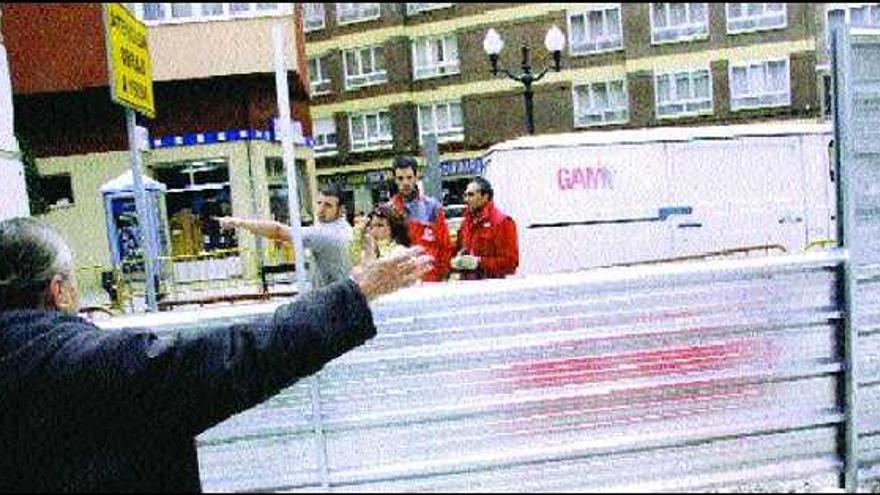 Los trabajadores de la obra indican a una joven por dónde salir, mientras que una mujer, en primer plano, señala el sitio contrario.