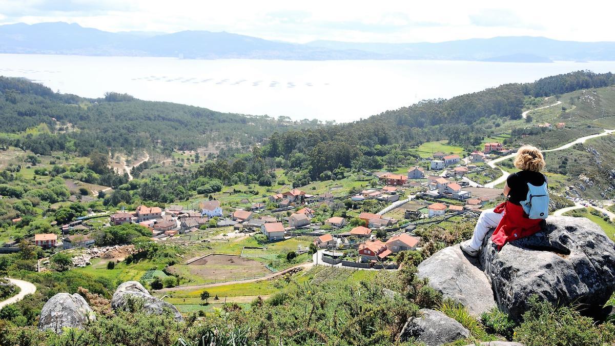 Una mujer contempla la ría desde el santuario del Monte do Facho, en Donón