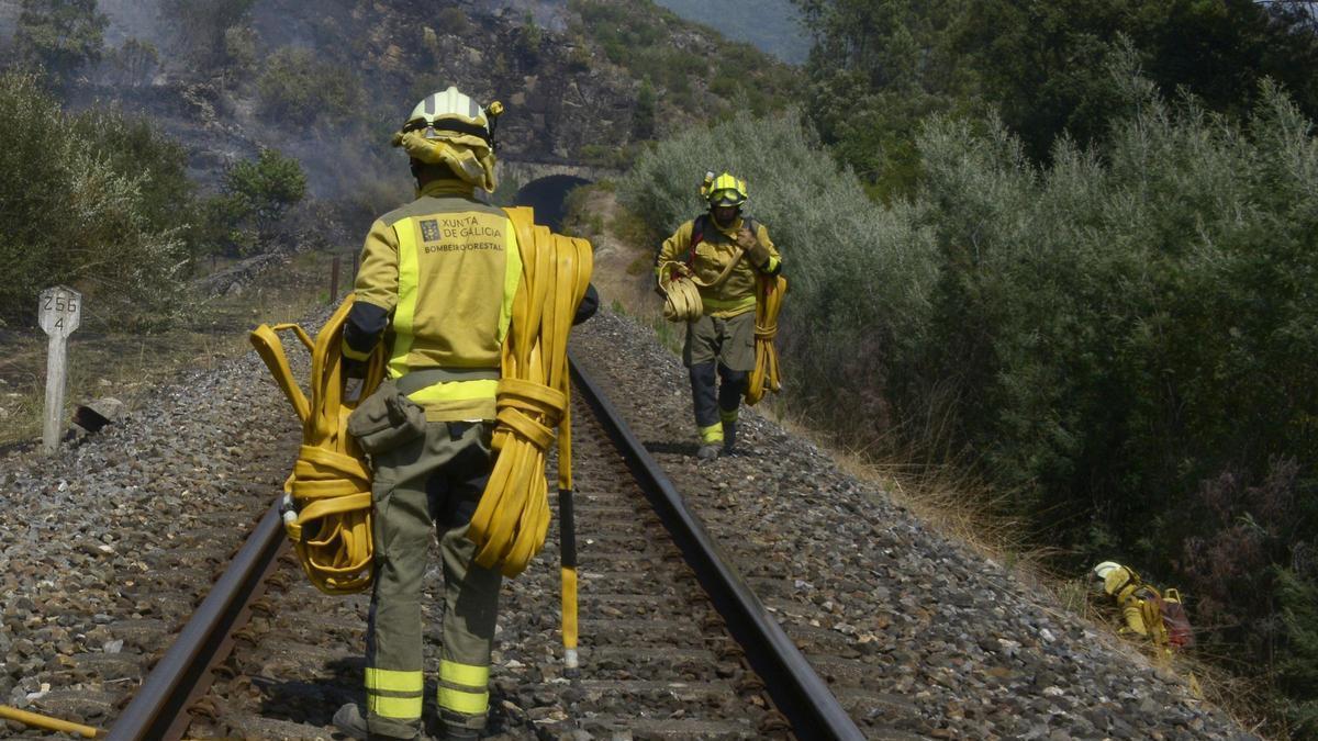 Bomberos y un hidroavión trabajan en las tareas de extinción del incendio forestal de Untes, a 13 de julio de 2026, en Ourense.