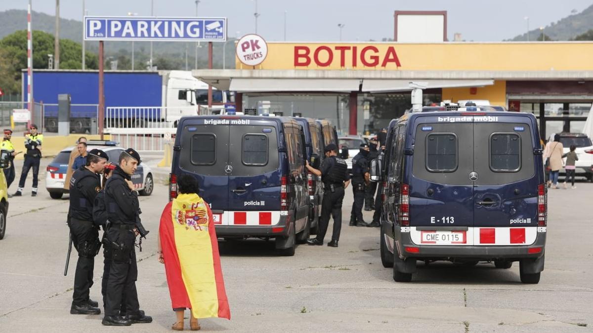 Una mujer con la bandera española habla con los Mossos, en la frontera con la Jonquera.