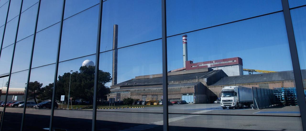 La fábrica avilesina de Saint-Gobain, reflejada en la fachada acristalada del edificio central de oficinas.