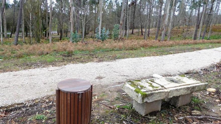 Banco de piedra y papelera al borde del sendero.  | // I.R.