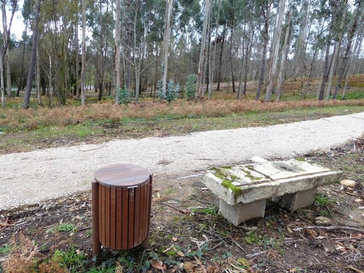 Sendero en una de las entradas al nuevo bosque forestal público; y cartel indicativo en otro acceso, por la rúa Denosiña.  | // I.R.