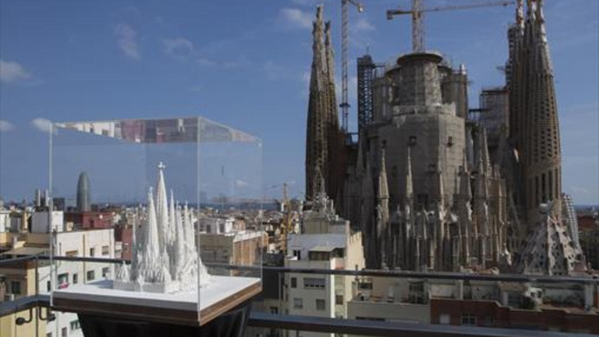 La Sagrada Família en obras vista desde el Hotel Ayre en la calle de Rosselló con una maqueta del templo ya acabado en primer término, ayer.