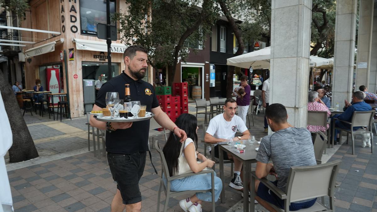 Un camarero sirve consumiciones en la plaza Santa Clara.