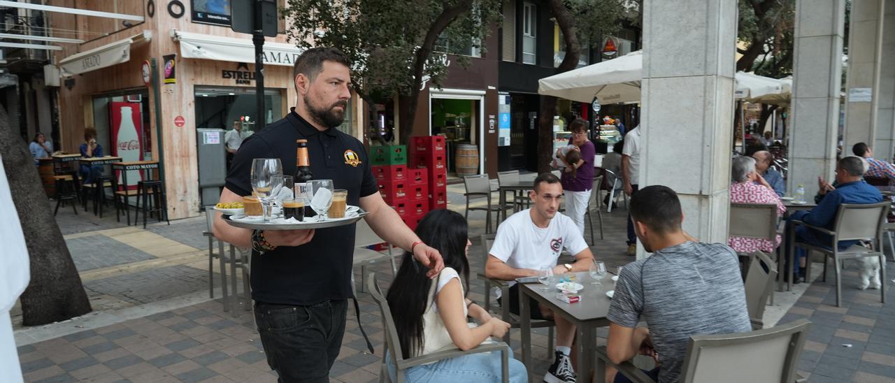 Un camarero sirve consumiciones en la plaza Santa Clara.