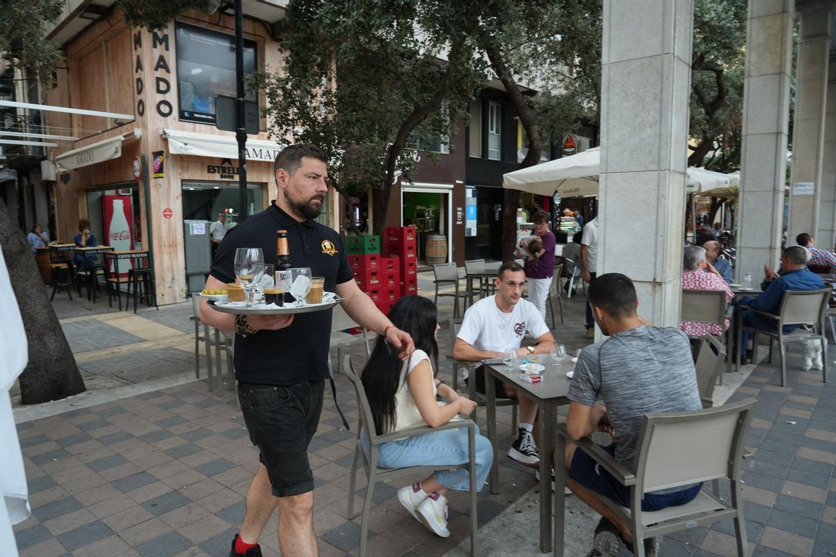 Un camarero sirve consumiciones en la plaza Santa Clara.