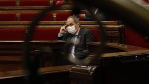 Quim Torra, en el Parlament, visto a través de una barandilla.