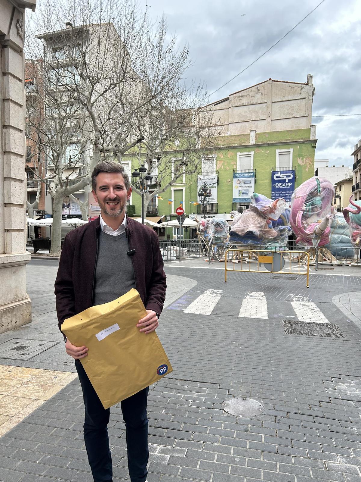 Víctor Soler, con el sobre remitido a las fallas, ante el monumento de Carrer Major i Passeig.