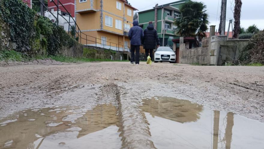 Unas personas pasean por el tramo de tierra del Camiño da Traída, en Cidadelle, ayer.