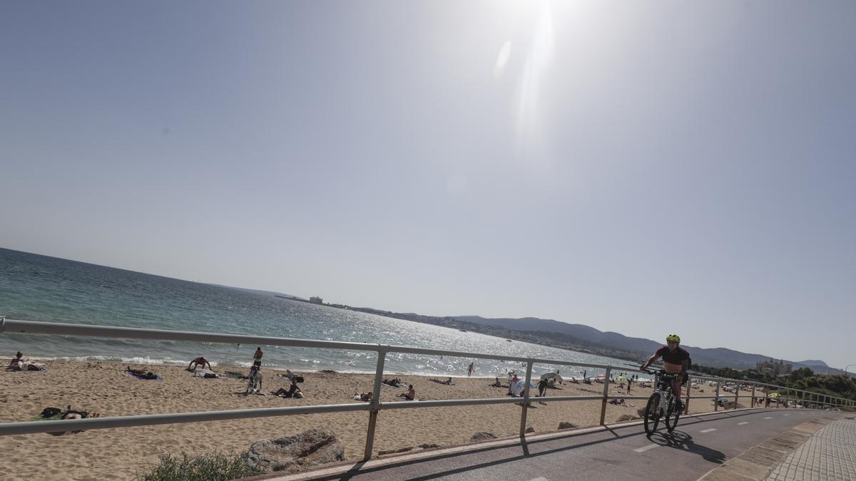 Un ciclista pasa por delante de la playa de Can Pere Antoni, en Palma