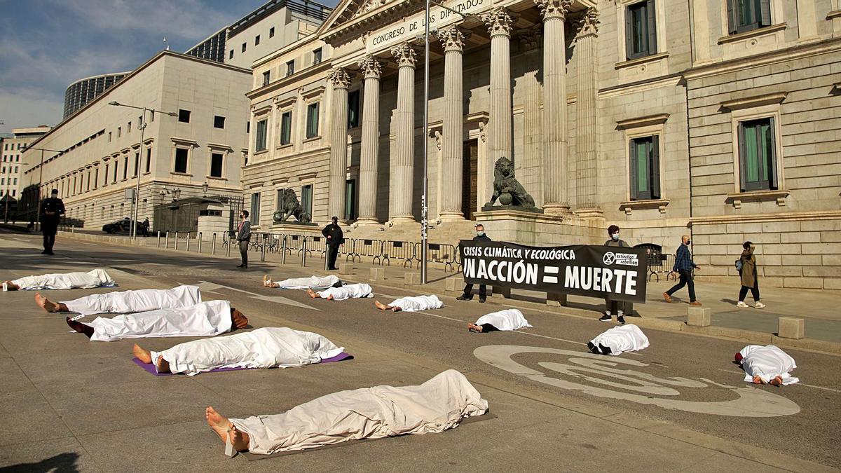 Activistas de Extinction Rebellion hicieron ayer un simulacro con “cadáveres” frente al Congreso para denunciar las muertes vinculadas a la crisis climática, entre ellas las pandemias, favorecidas por la deforestación.