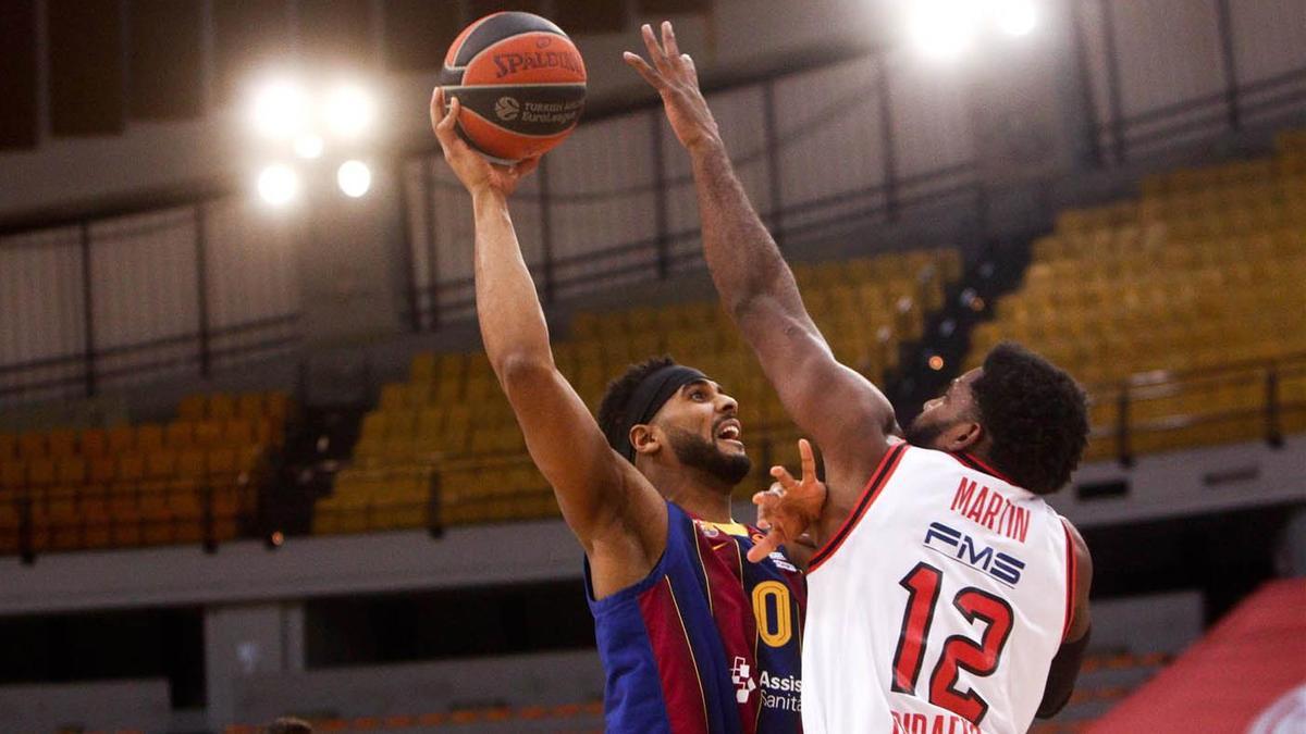 Davies trata de superar a Martin en el duelo ante Olympiacos