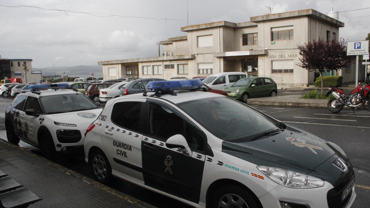 Vehículos oficiales de la Policía Local y de la Guardia Civil estacionados ante la Casa do Mar de Bueu.