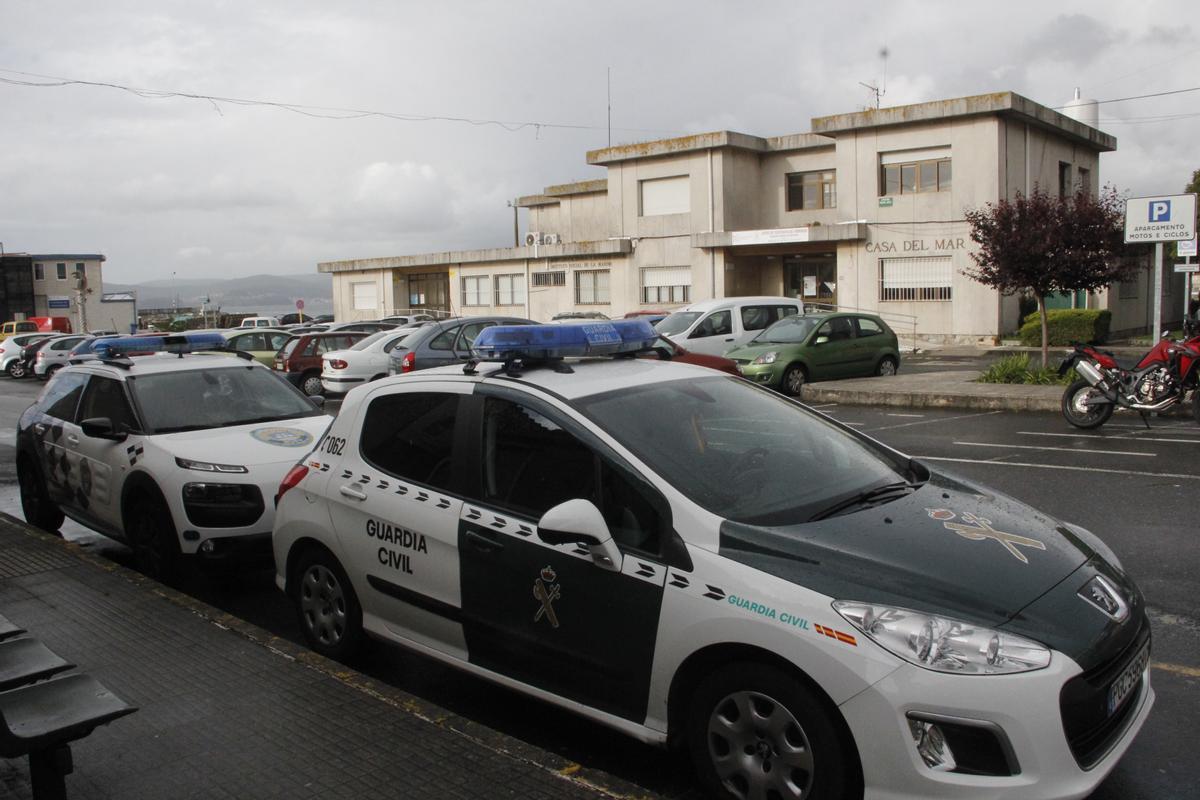 Vehículos oficiales de la Policía Local y de la Guardia Civil estacionados ante la Casa do Mar de Bueu.