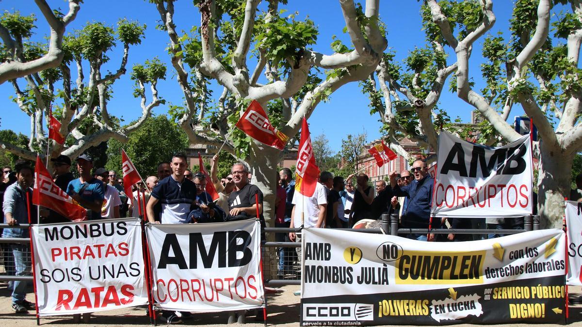 Los trabajadores de Monbus y Julià con pancartas que denuncian su situación laboral frente al Parlament.