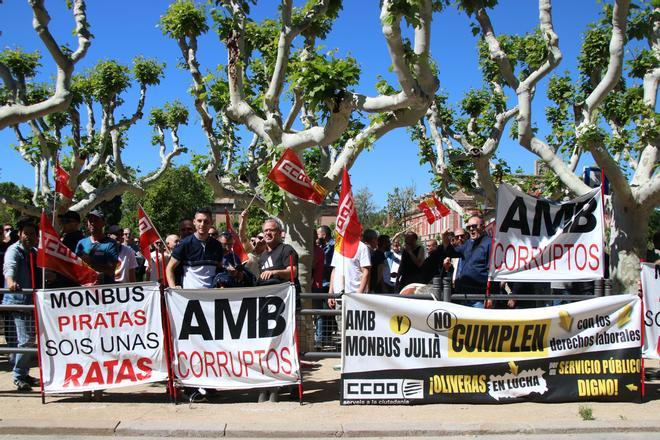 Los trabajadores de Monbus y Julià con pancartas que denuncian su situación laboral frente al Parlament.