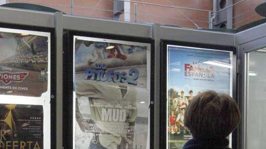 Una mujer observa la cartelera en un cine gallego. / bernabe / gutier