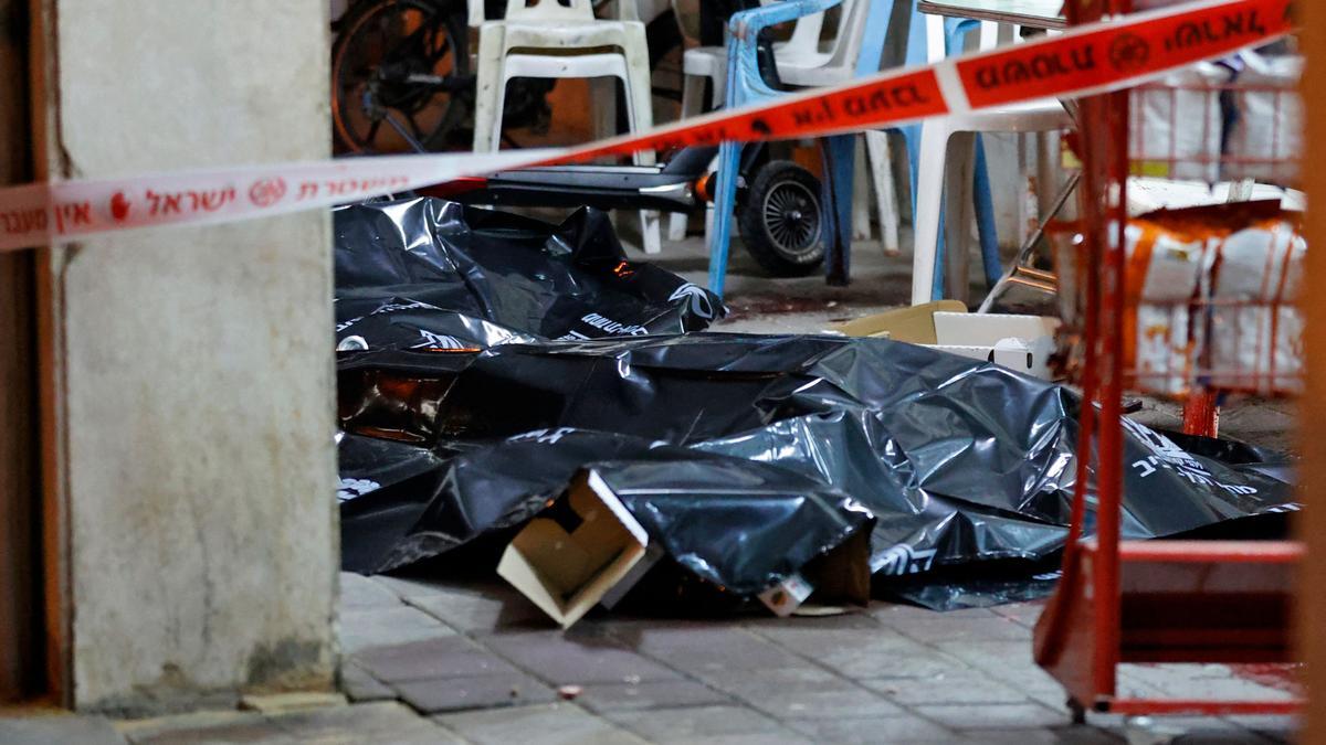 Los cuerpos de algunas de las víctimas del atentado en la ciudad de Bnei Brak, próxima a Tel Aviv, yacen en el suelo cubiertos con plásticos.