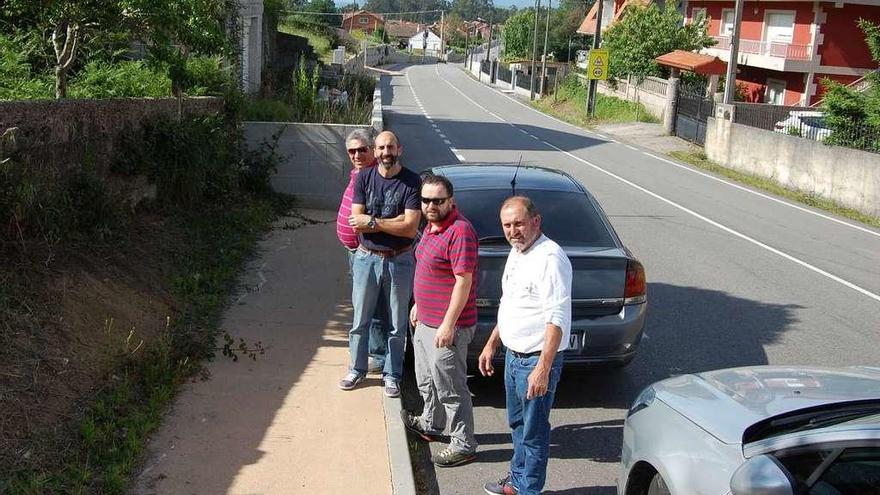 Los vecinos de Vilar, ayer, junto a un muro obstaculiza las aceras en la Estrada do Galleiro. // FdV