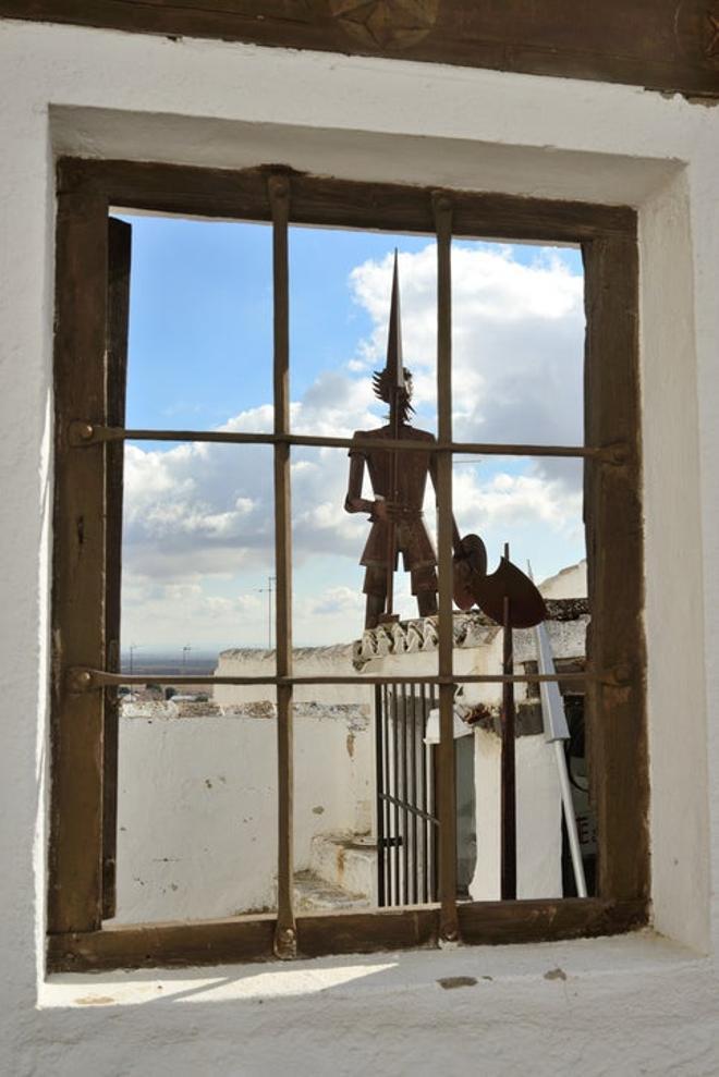 Molinos Campo de Criptana Tren de los molinos Window with a figure of Don Quixote in the background in Campo de Criptana.