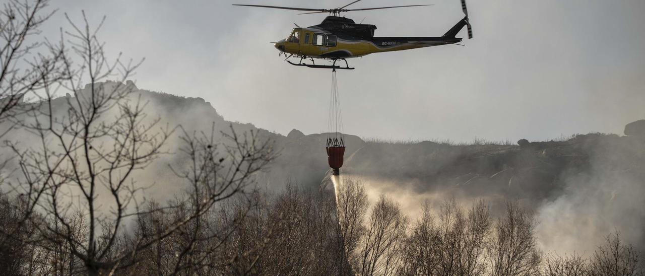 Un helicóptero participa en la extinción de un incendio en Muíños.