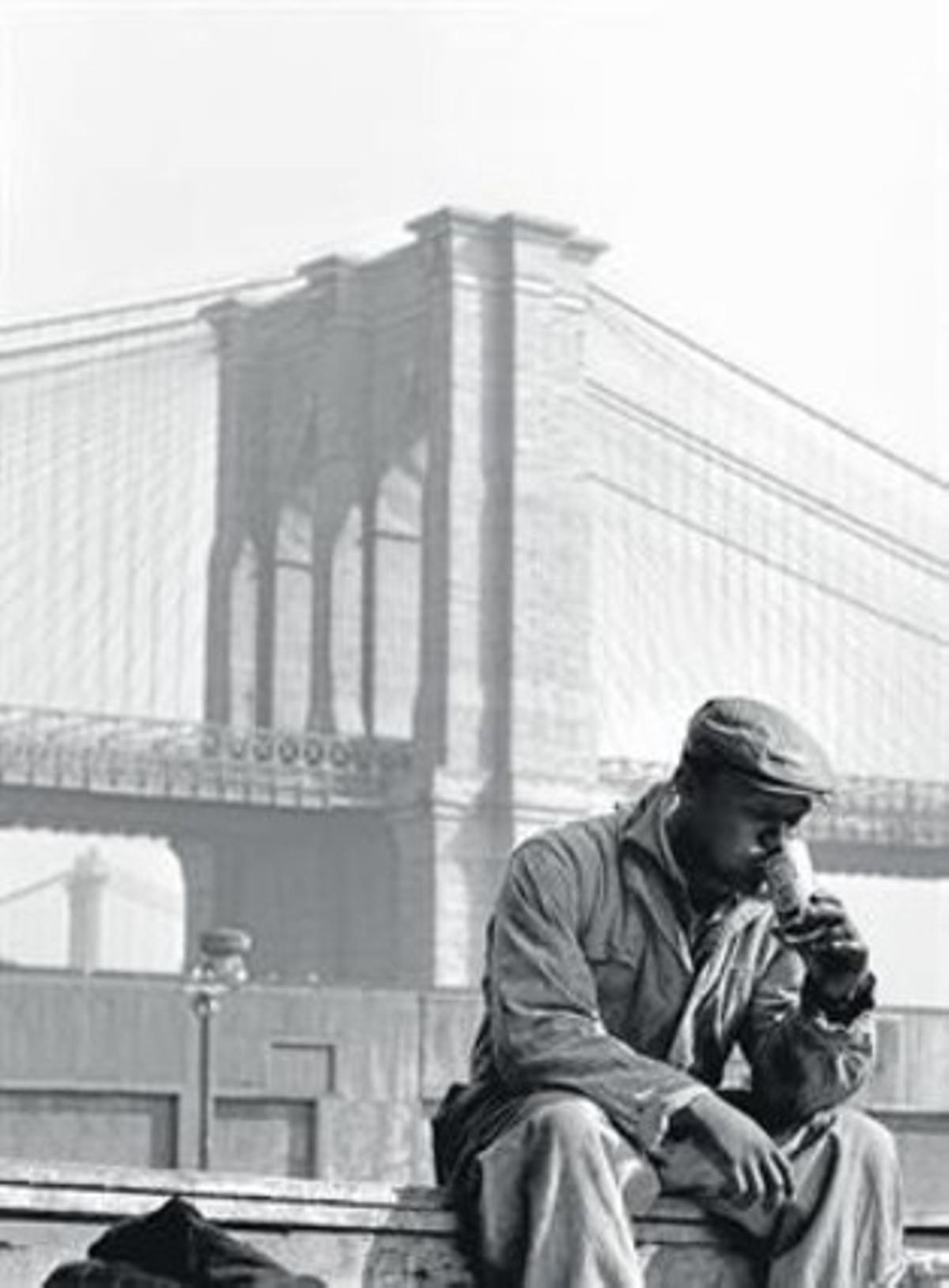 Un treballador descansa una mica davant el pont de Brooklyn, el 1955.