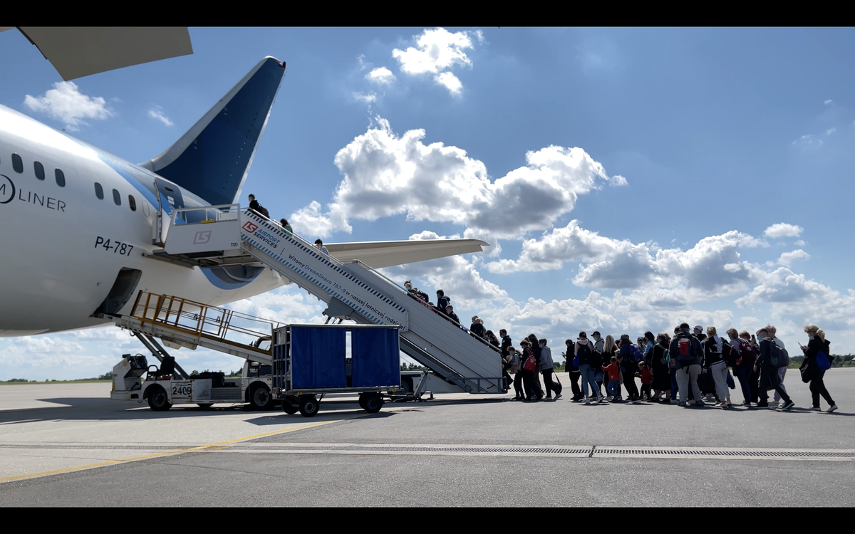 Un grupo de ucranianos se sube al Boeing de Solidaire en Varsovia rumbo a Madrid.