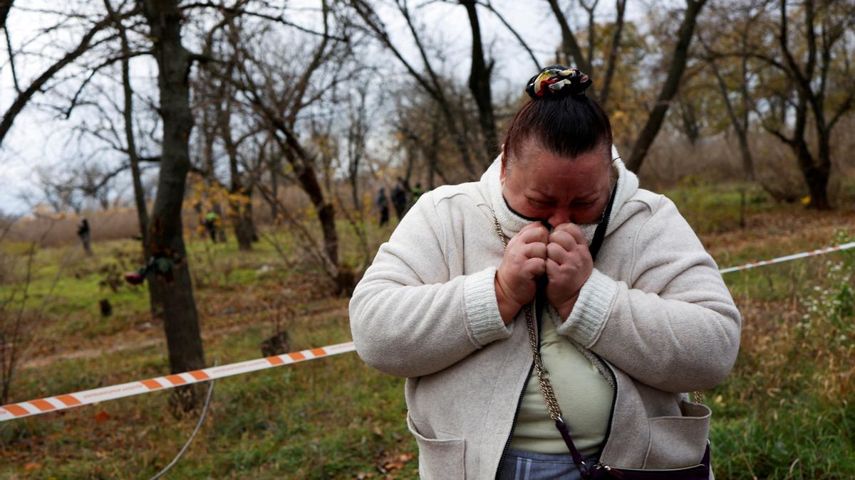 Una mujer llora en un parque en el que se encontraron evidencias de tortura en Jersón.