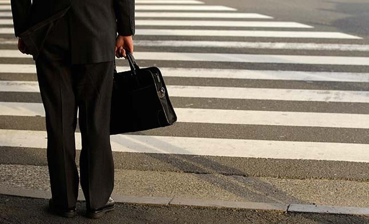 Un empresari espera per travessar un pas zebra a Tòquio (Japó). Les grans fàbriques nipones tenen males expectatives per als pròxims tres mesos.