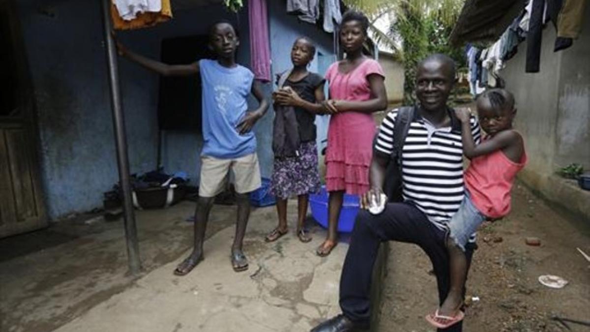 Un superviviente del ébola sostiene a la hija de una amiga que falleció por la enfermedad, en Sierra Leona.