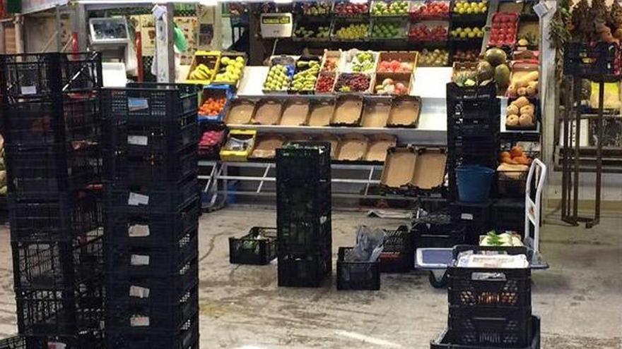 Cajas de frutas y verduras apiladas en el Mercado Municipal ante las filtraciones de agua en su interior.
