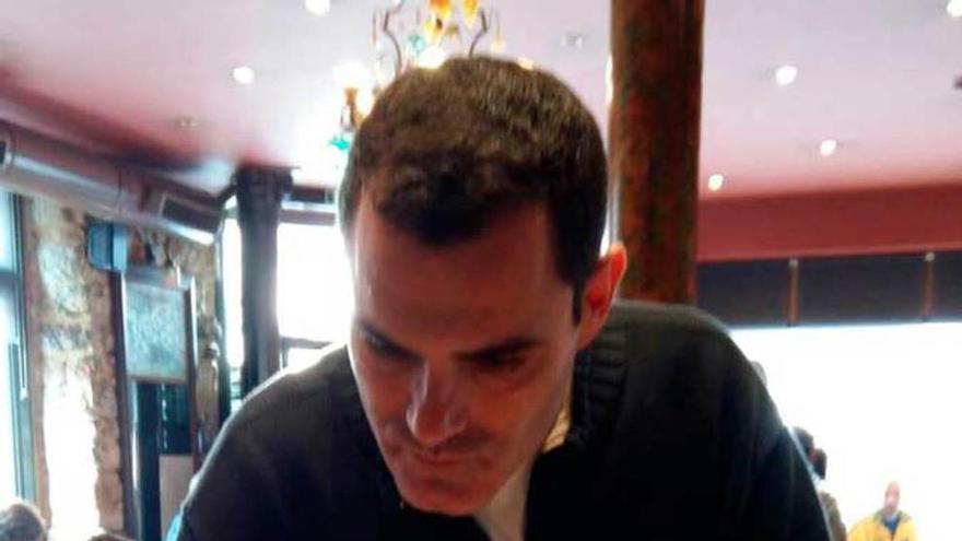 Rafael Logorit firma, en el Café de Vicente, en Villaviciosa, a favor de la senda a El Puntal.