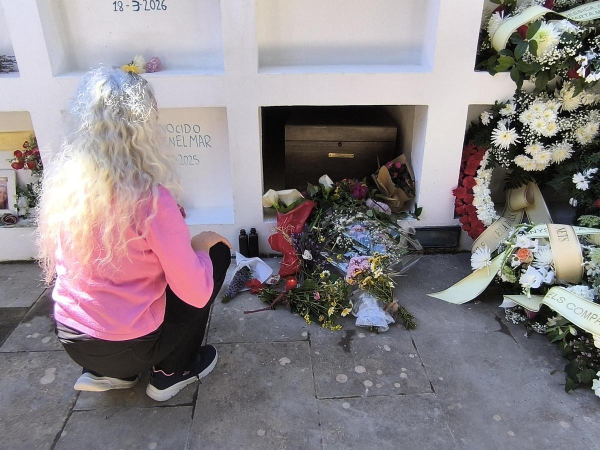 Una de las asistentes al improvisado funeral deposita unas flores frente al ataud