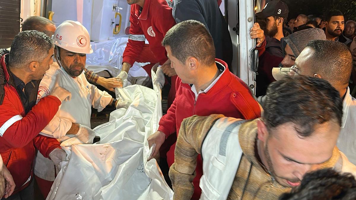 Paramédicos sacan de una ambulancia el cuerpo de uno de los 15 sanitarios y rescatistas asesinados.