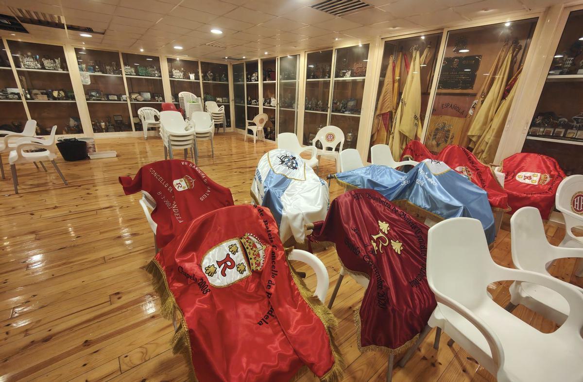 Las banderas secando en un sala de trofeos con los techos dañados y cubos por las goteras. | GONZALO NÚÑEZ