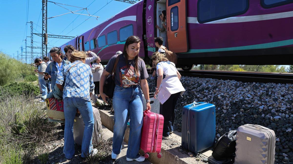 Usuarios se bajan de un tren de alta velocidad detenido cerca de València por el apagón.