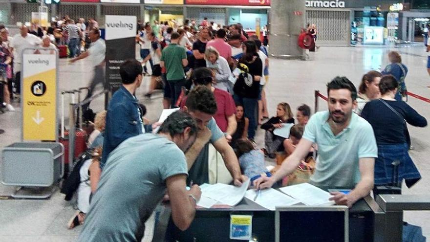 La cola de afectados, formulando reclamaciones anoche en el mostrador de Vueling del aeropuerto de Málaga.