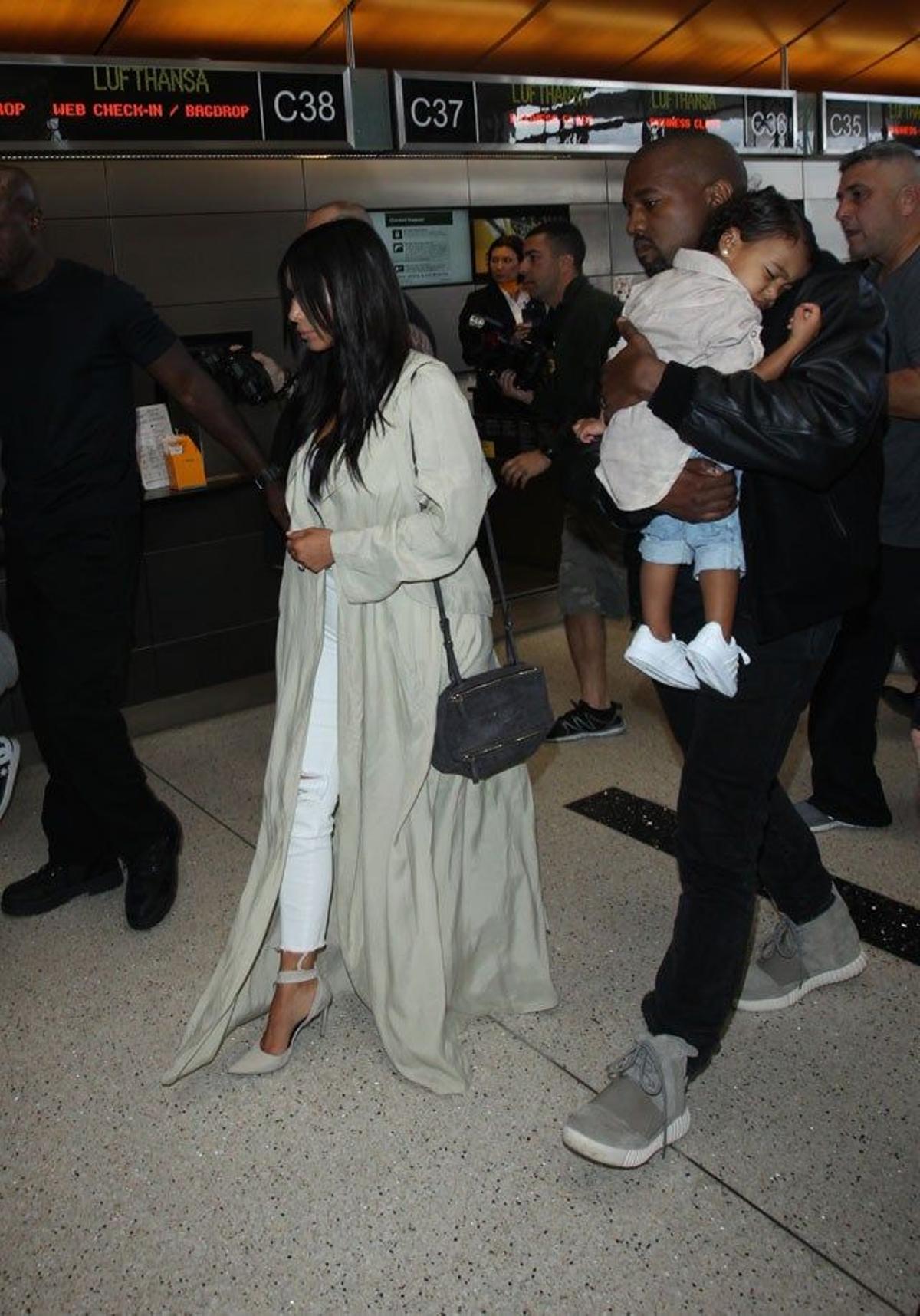 Kim Kardashian y Kanye West caminan por la terminal del aeropuerto