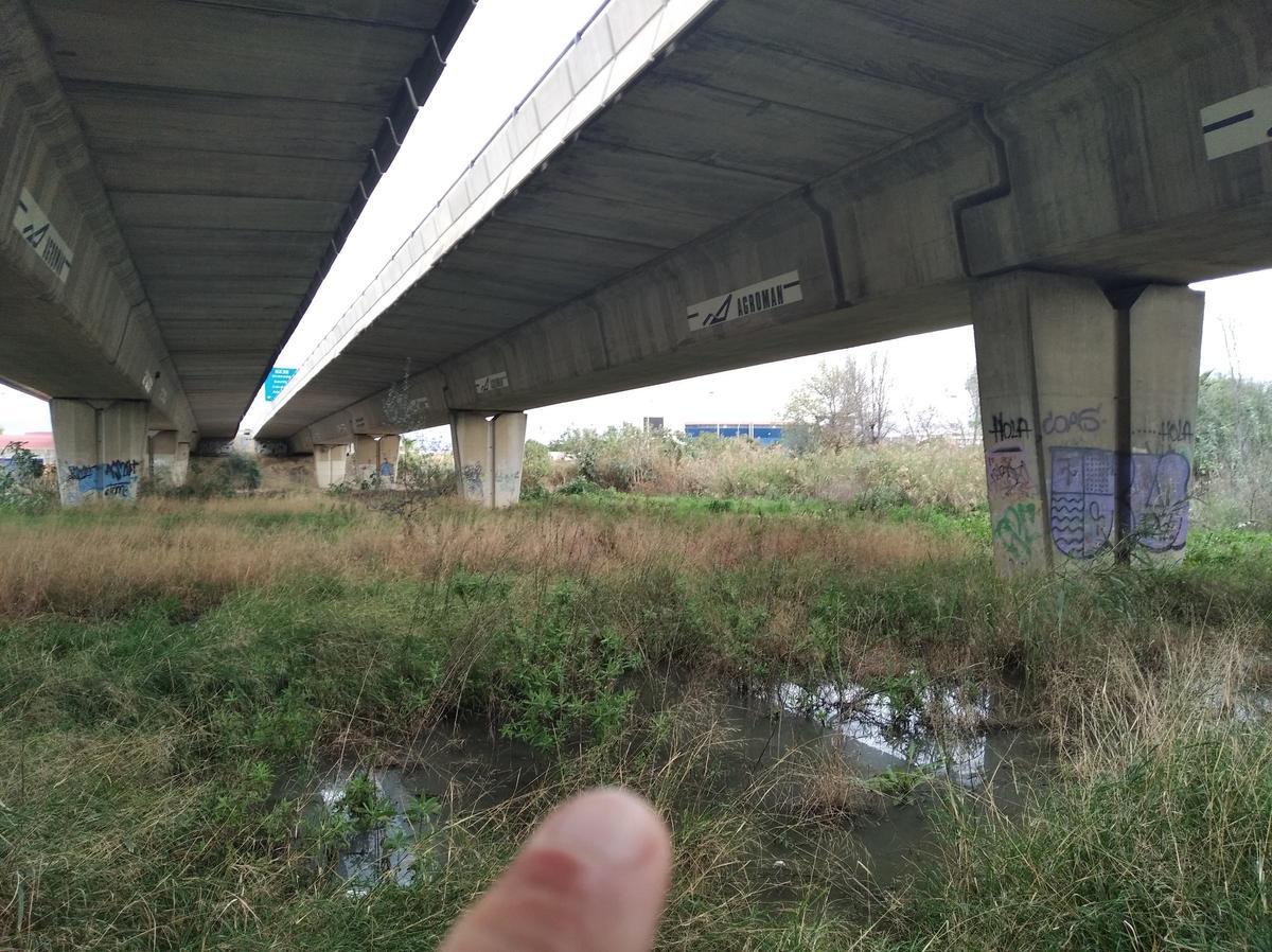 Charcos del agua maloliente en las zapatas del puente de la Ronda Oeste.