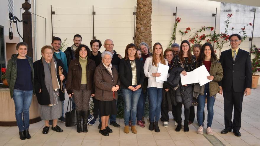 Las tres alumnas distinguidas posan con familiares, amistades y dirigentes del Ayuntamiento y del CUM.