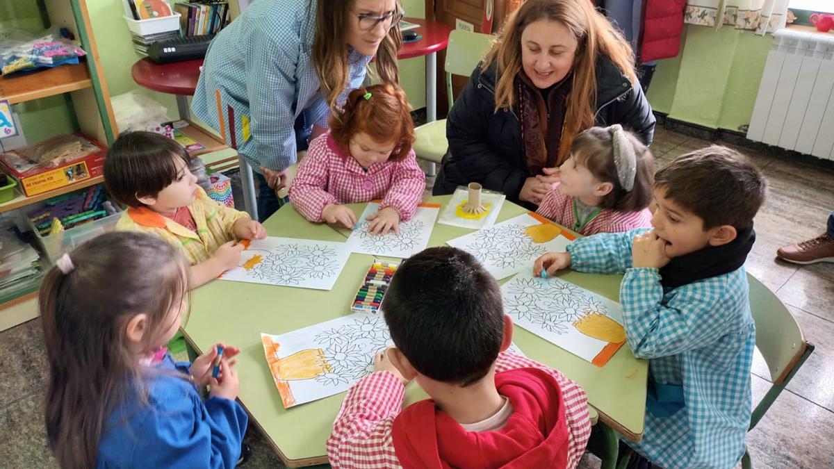 La consejera de Educación, Lydia Espina y la maestra Lucía Riesco, en el aula de Infantil de Santa Eulalia de Oscos, con varios alumnos.