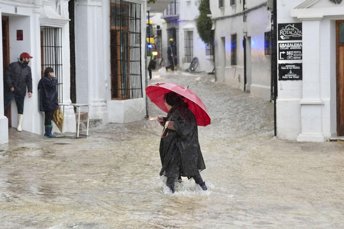 Una vecina de Grazalema (Cádiz) camina por una calle inundada. EFE/Román Ríos