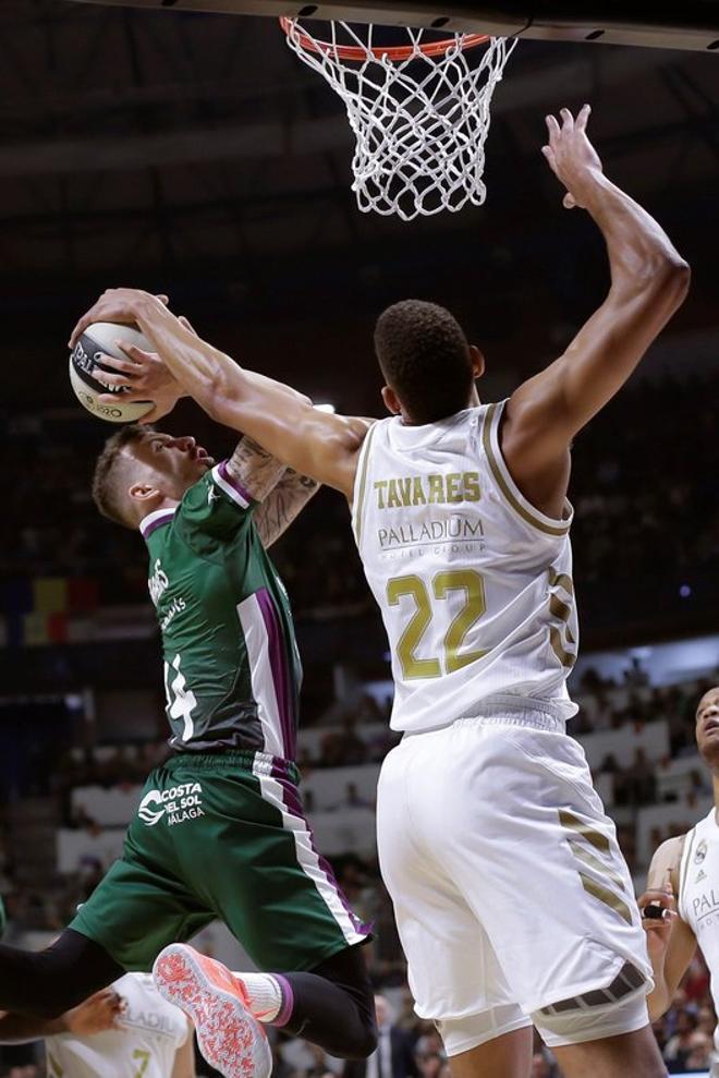 El base estadounidense de Unicaja Málaga, Josh Adams (i), taponado por el pivot del Real Madrid, Walter Tavares, durante el partido correspondiente a la final de la Copa del Rey que se disputa esta tarde en el Palacio de Deportes José Mª Martín Carp